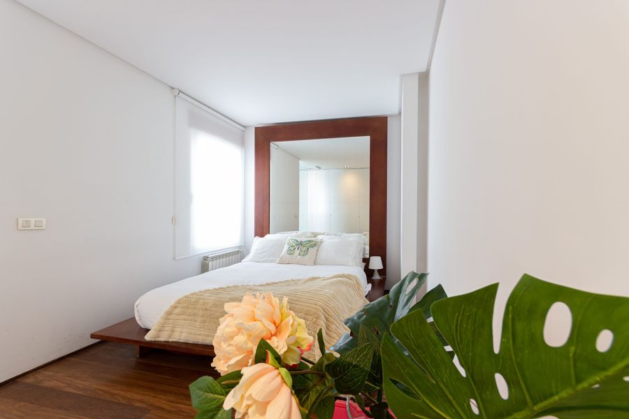 Dormitorio clásico con espejo en el cabecero