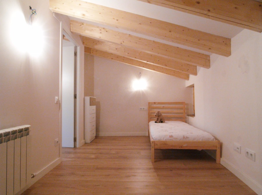 Dormitorio con vigas de madera