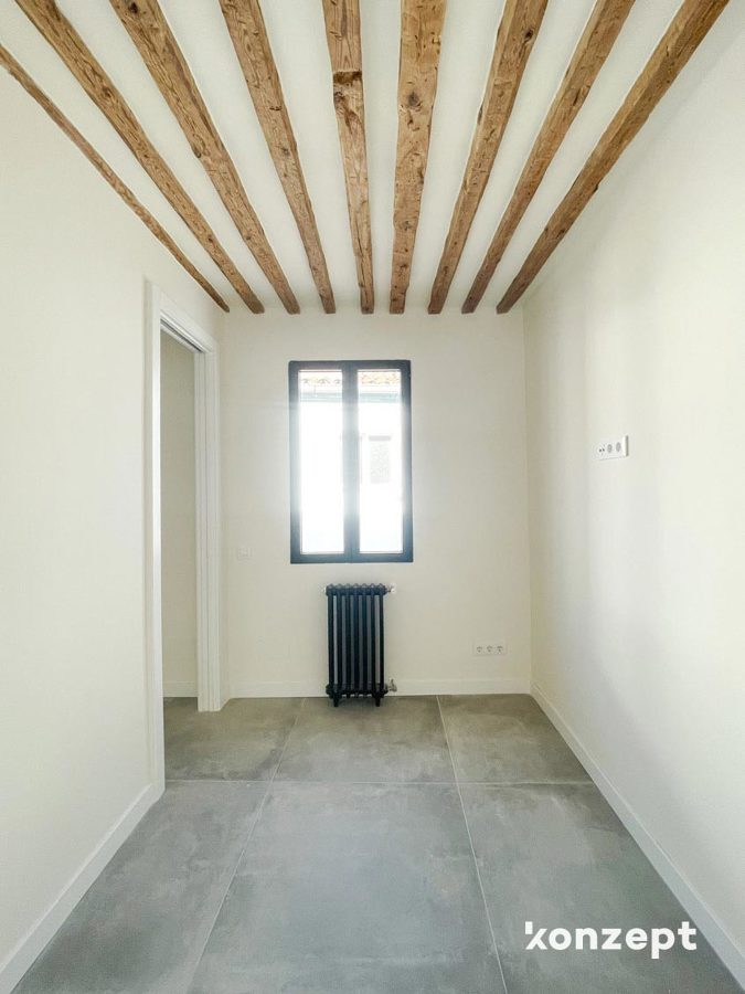 dormitorio con vigas de madera vistas