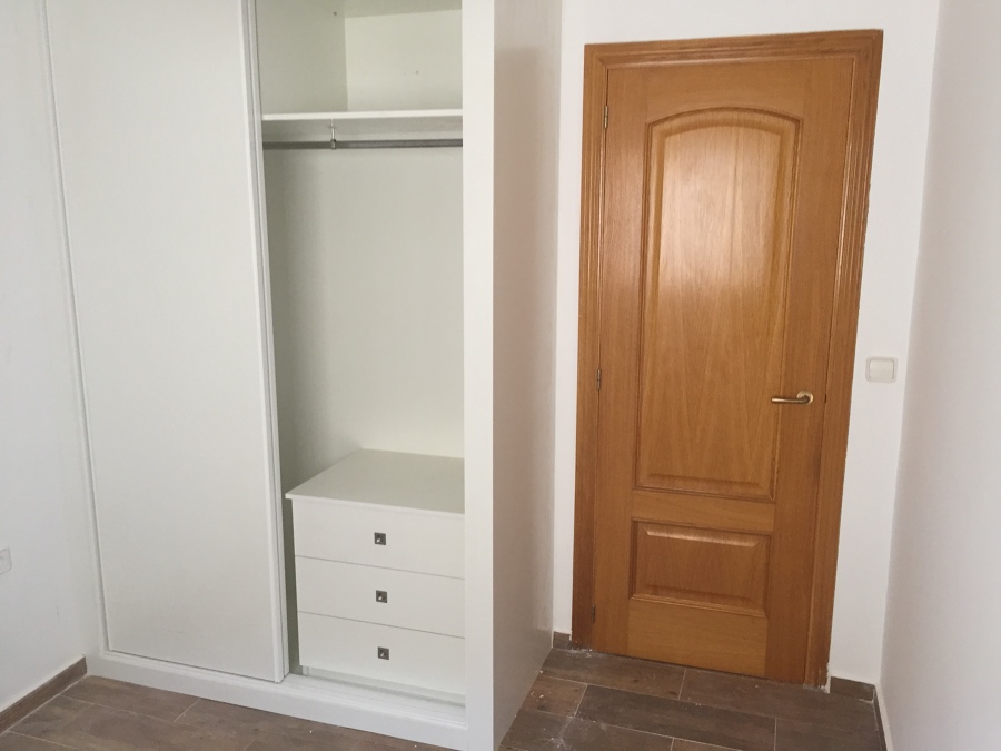 El armario tiene 2 puertas correderas de melamina  blanca.  ( no es lacado).