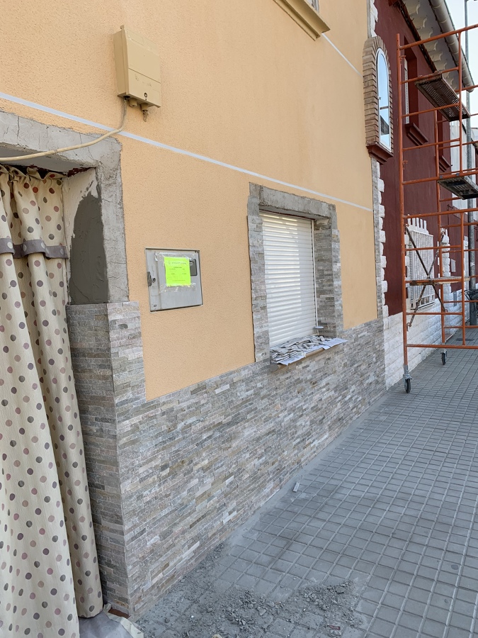 Empezar a poner piedra natural premontada en el zocalo y alrededor de las ventanas y puerta.