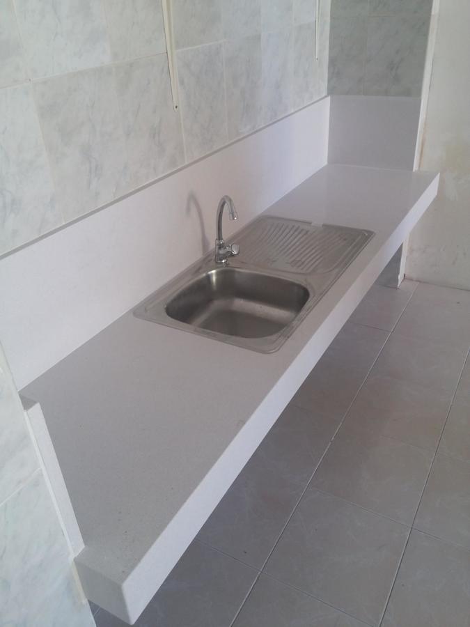 Encimera en aula con fregadero y grifería.