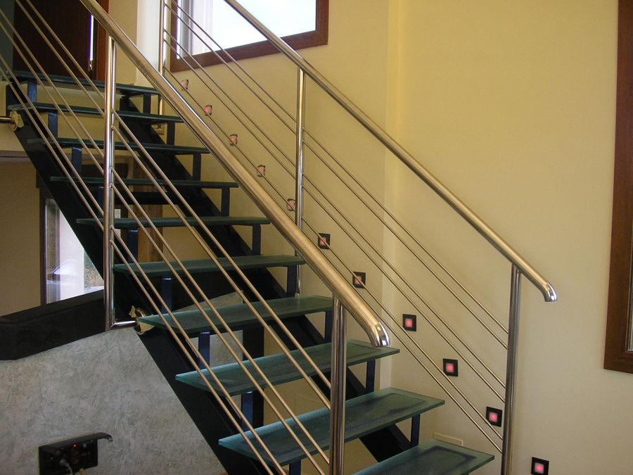 Escalera con peldaños de cristal y barandilla inox.