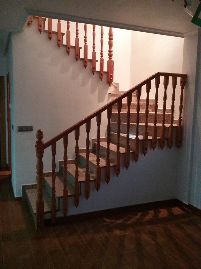 ESCALERA DE GRANITO EN ROJO PORRIÑO CON BARANDILLA TORNEADA EN PINO Y SUELO EN PLAQUETA COLOR ROBLE.