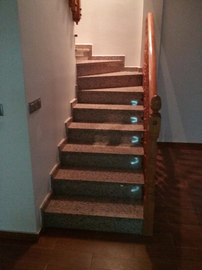 ESCALERA DE GRANITO EN ROJO PORRIÑO CON BARANDILLA TORNEADA EN PINO Y SUELO EN PLAQUETA COLOR ROBLE.