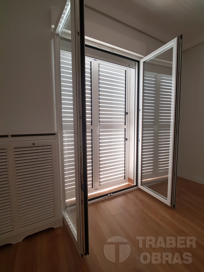 Estado terminado. Puerta balconera de aluminio con celosía.