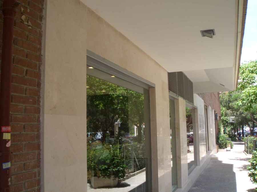 Fachada chapada en mármol crema marfil pulido.