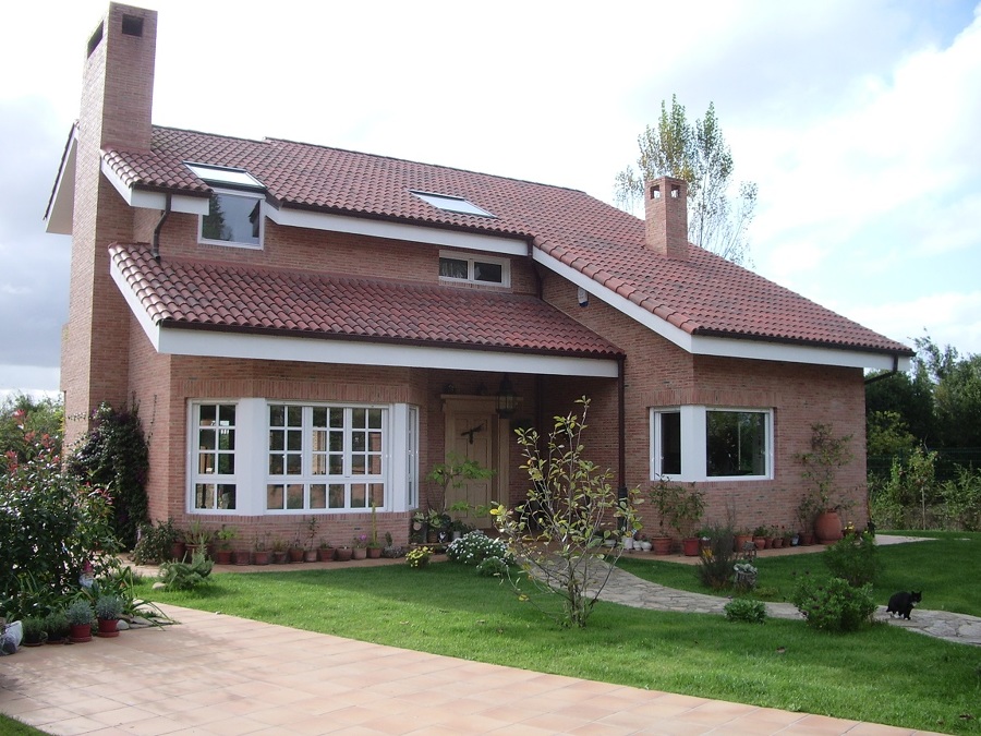 Fachada de ladrillo visto, cubierta,  jardín y aceras