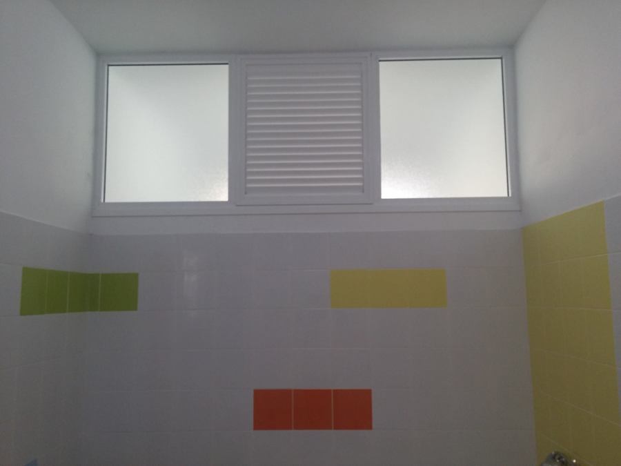 Fijo de aluminio con lamas centrales y cristales laterales.