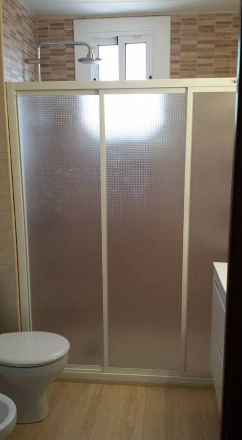 Foto del aseo terminado con la mampara modelo única de 3 puertas correderas y acrílico grafito.
