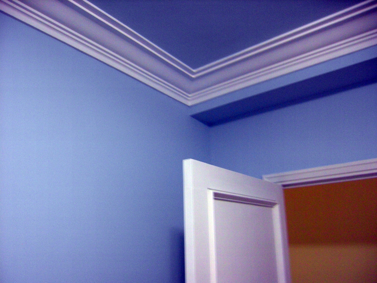 Habitación azul, moldura blanca y puerta lacada en blanco