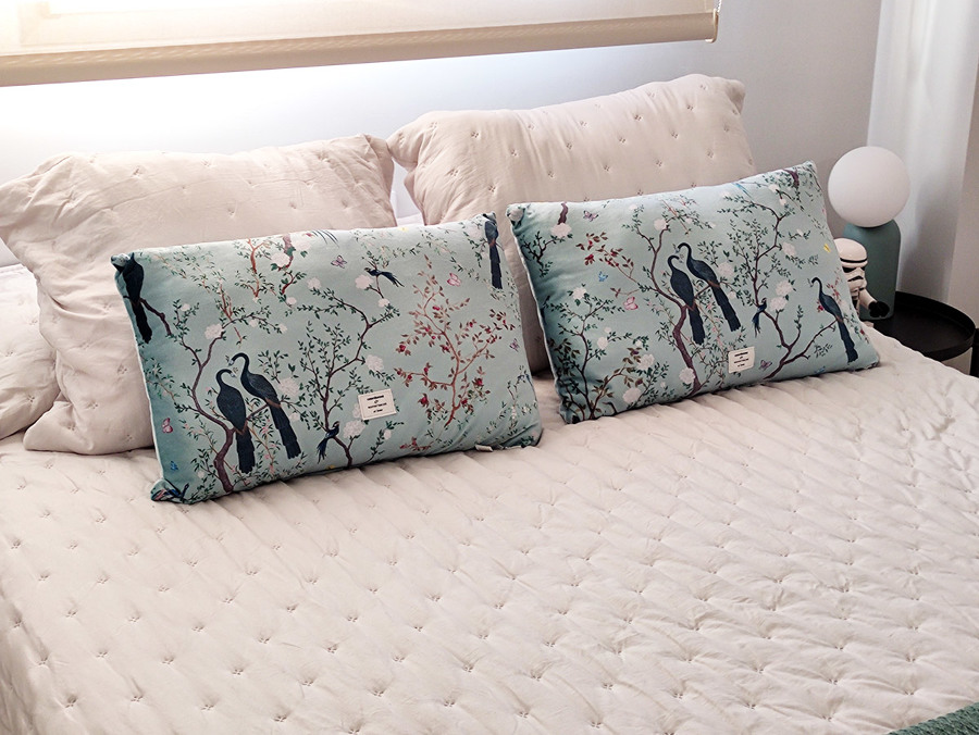 Habitación principal decorada en tonos blancos, dorados y turquesas.