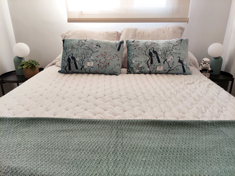 Habitación principal decorada en tonos blancos, dorados y turquesas.