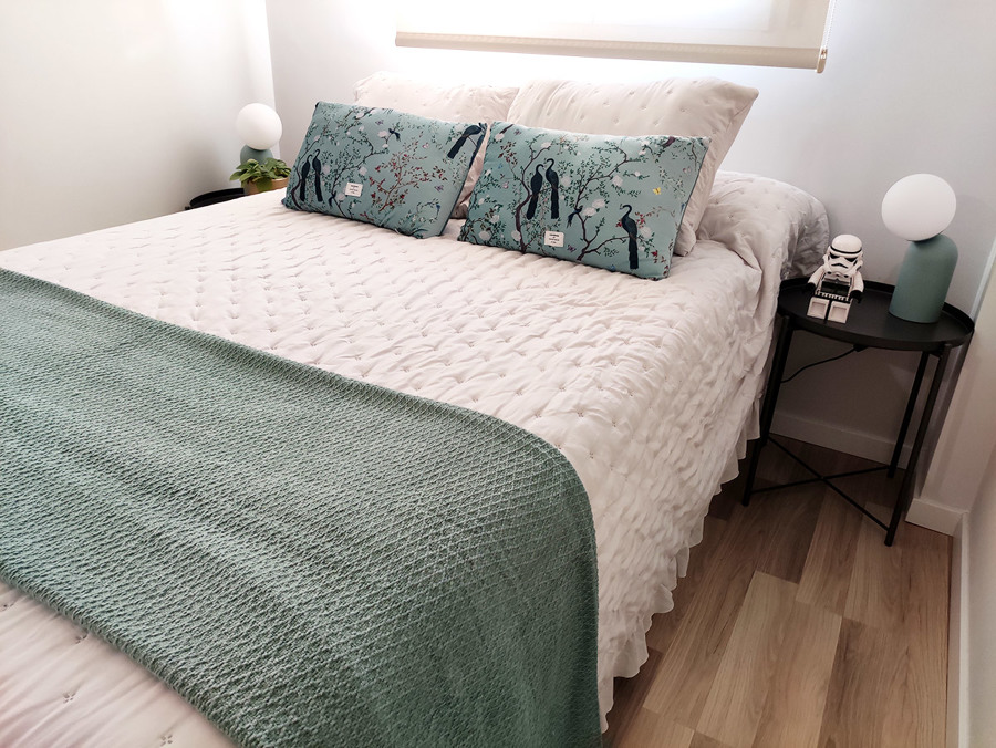 Habitación principal decorada en tonos blancos, dorados y turquesas.