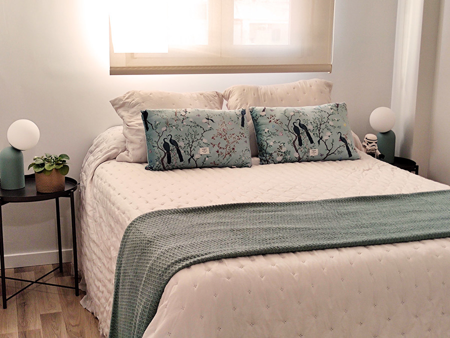 Habitación principal decorada en tonos blancos, dorados y turquesas.