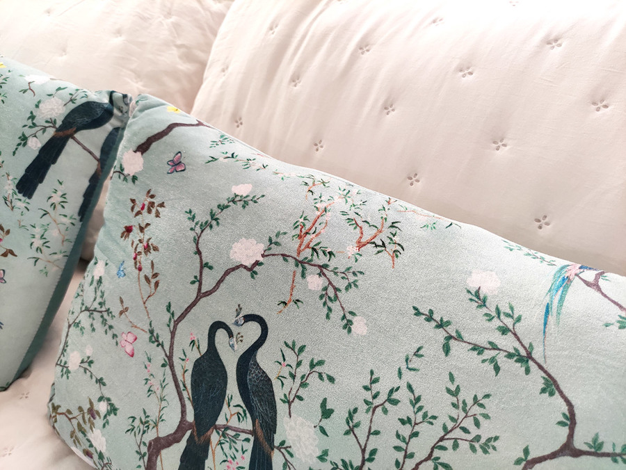 Habitación principal decorada en tonos blancos, dorados y turquesas.