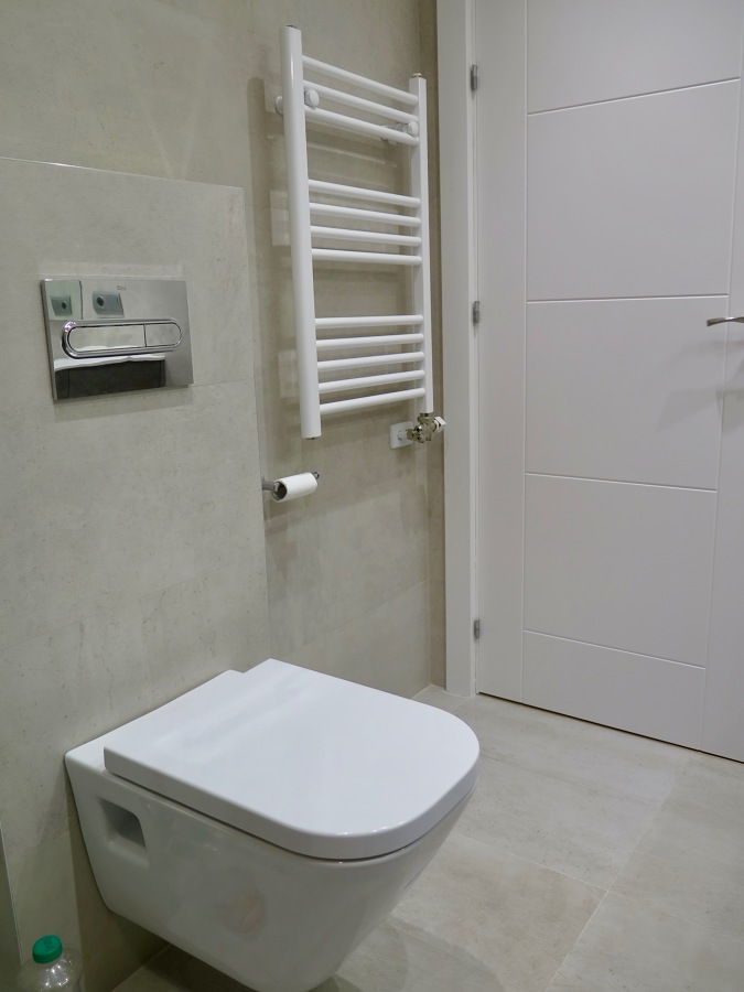 Inodoro suspendido y radiador toallero.