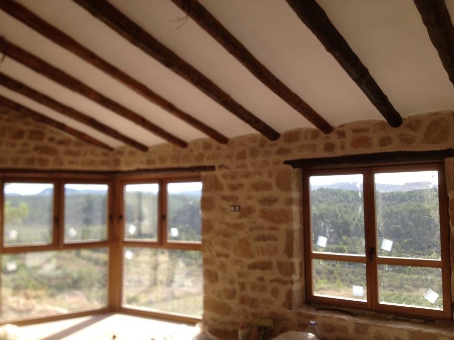 Interior casa rústica con ventanas de iroko