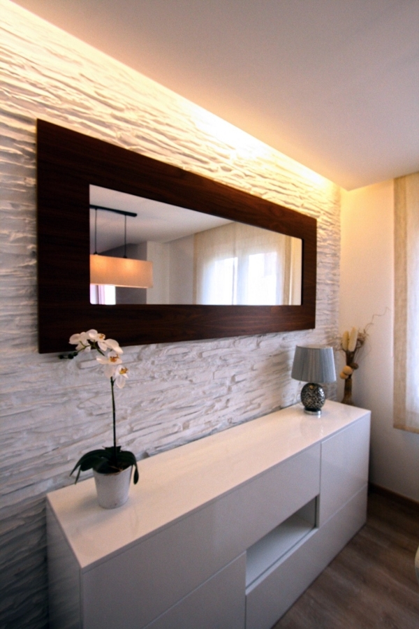 Mueble auxiliar del comedor con pared decorativa e iluminación indirecta.