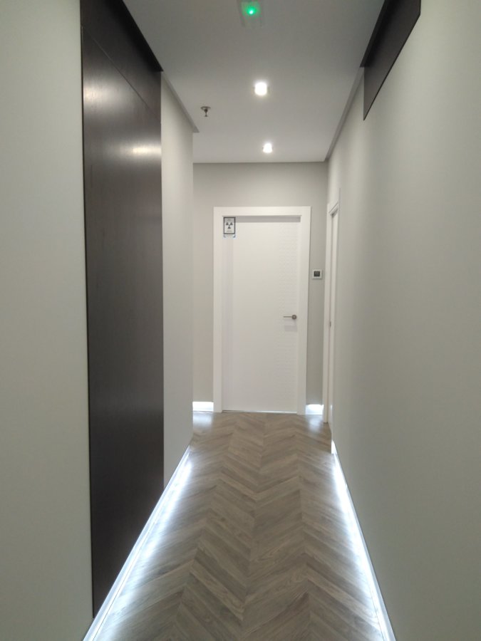 Pasillo con luces led panel de madera y puertas correderas insonorizadas