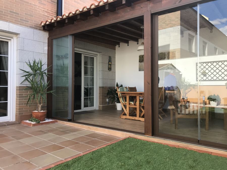 Pérgola de madera adosada con cerramiento de vidrio