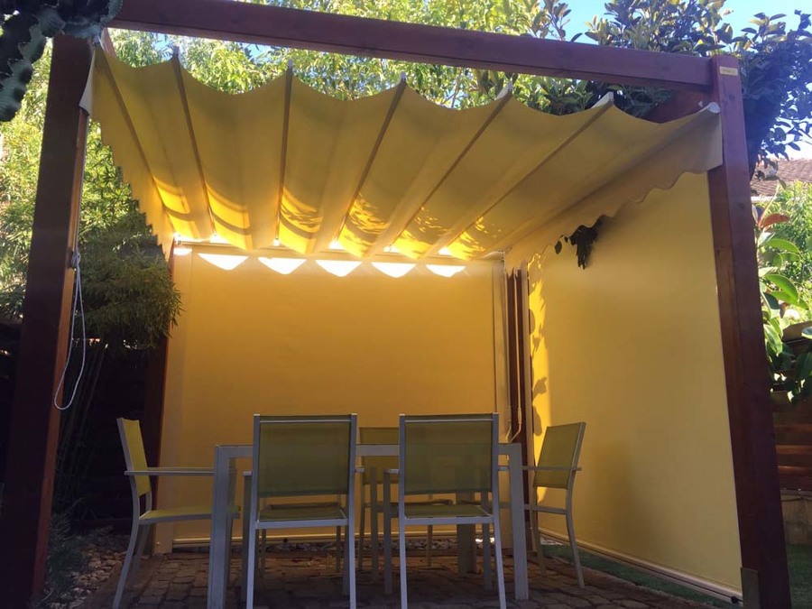 Pérgola de madera con toldo corredero y toldos verticales