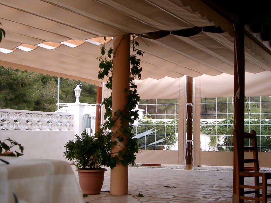 Pérgola de madera con toldo y cortinas tensadas