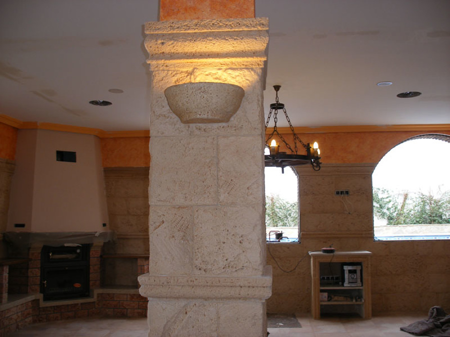 Pilar revestido de piedra artificial con apliques de luz.