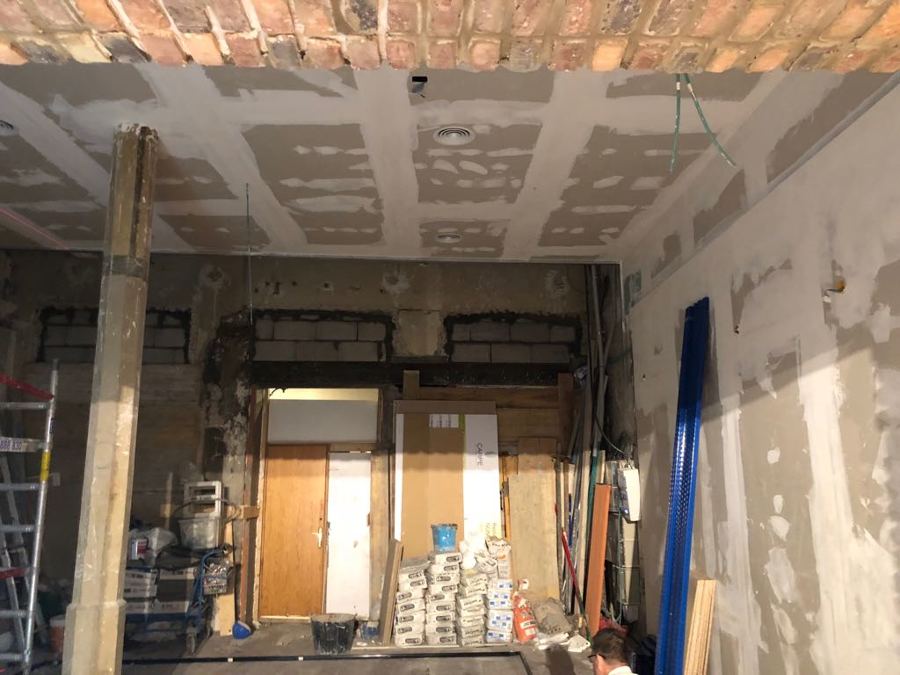 Pintura interior local comercial preparado de paredes, techos y columnas