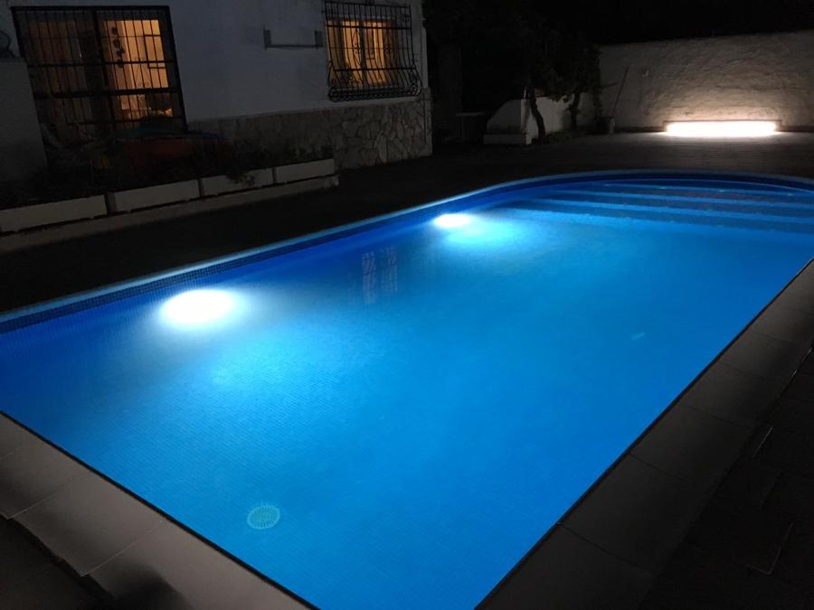 Piscina y su entorno de noche.