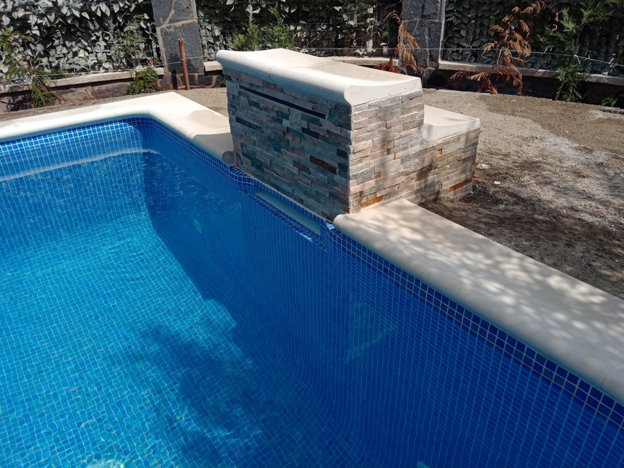 Podio con  cascada y revestimiento imitación piedra