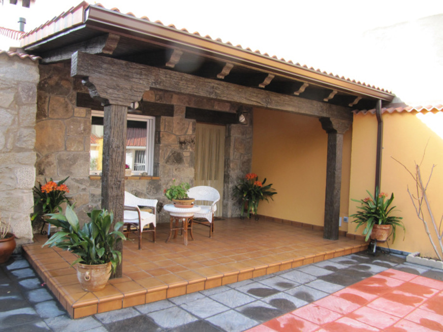 Porche rústico con paredes con piedra natural