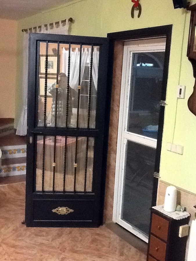 Puerta de paso abatible realizada con forja artística y cristal laminado de seguridad.