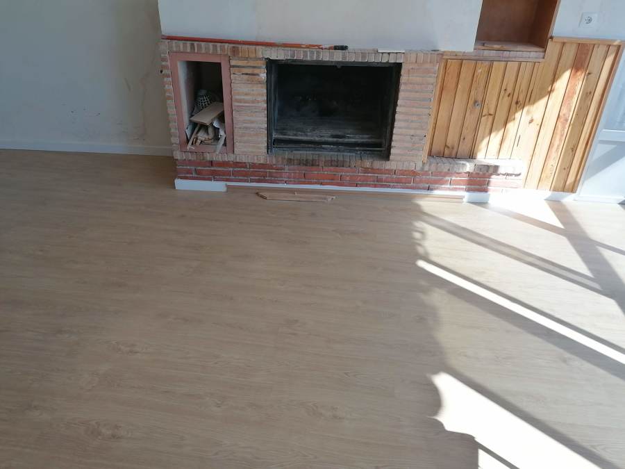 Tarima flotante en habitación con chimenea