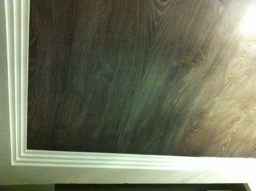 Techo de láminas de madera tono gris y luz indirecta con tabica en moldura