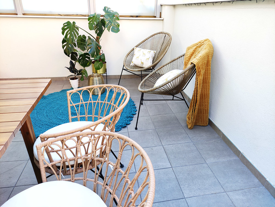 Terraza decorada con piezas en acabados naturales como maderas y fibras naturales.