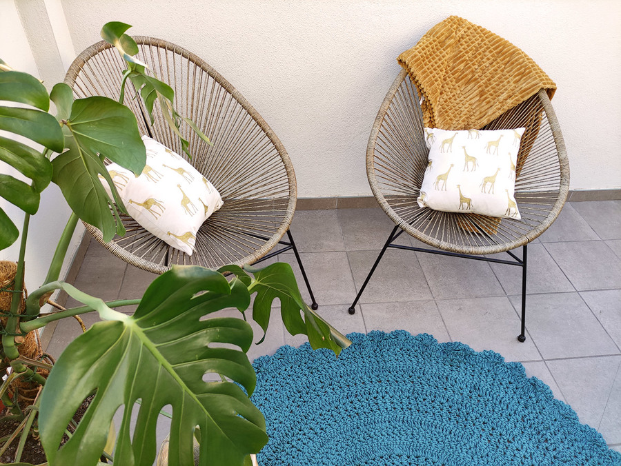 Terraza decorada con piezas en acabados naturales como maderas y fibras naturales.