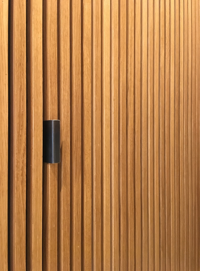 Tirador diseñado para puerta del baño de cortesía incluido en el volumen revestido