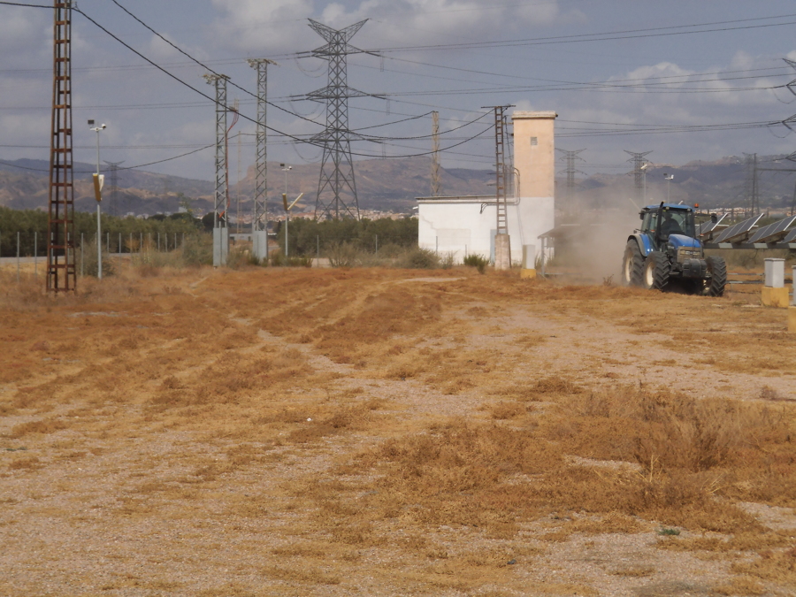 tractor con desbrozadora de cadenas suspendida en pleno trabajo