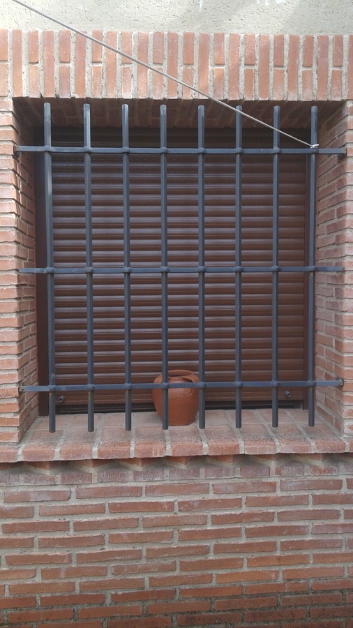 Ventana con persiana y rejas