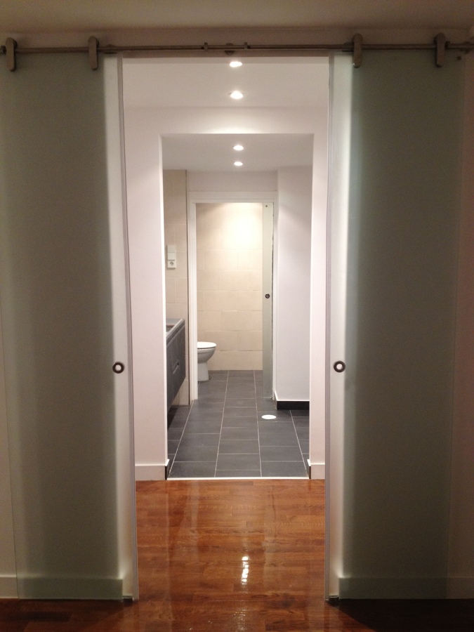 Vestidor abierto al baño principal con puertas de cristal
