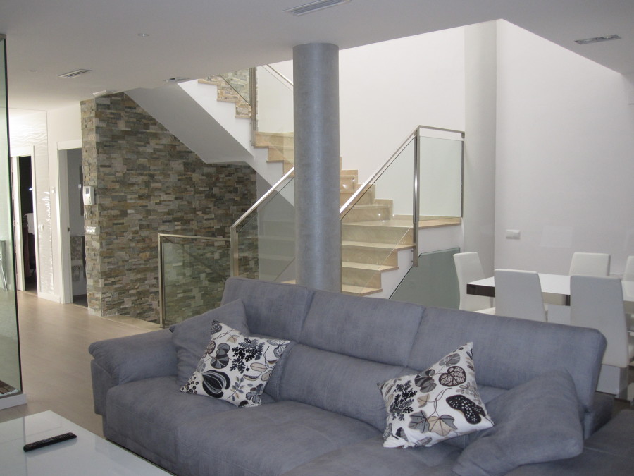 Vista de salon y escalera al fondo.