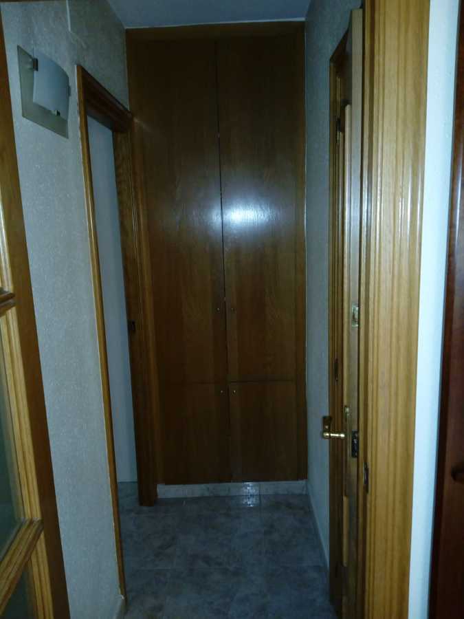 Vista distribuidor con gotelé y color madera en puertas