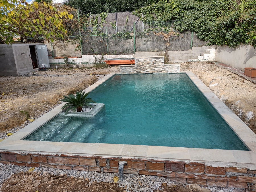 Vista general de la piscina y el local técnico..