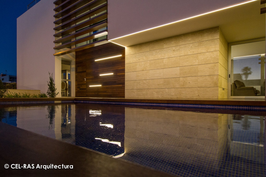 Vista nocturna de la fachada principal de la vivienda