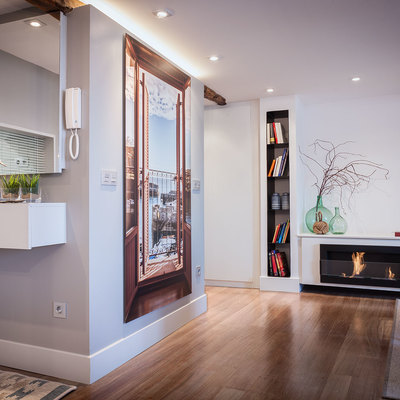 A la izquierda, espejo sobre mueble en el hall de entrada, a la derecha chimenea en el salón