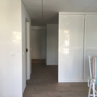 Transformación de cochera en apartamento con baño, cocina, salón y dos dormitorios