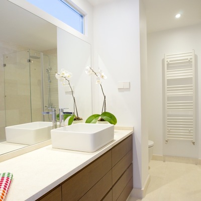 Baño con mobiliario a medida. Solados, alicatados y encimera en piedra blanco fósil