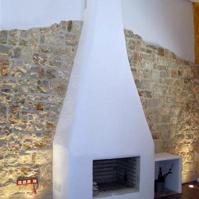 Chimenea terminada con pared de piedra e iluminación