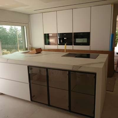 Diseño e instalación de cocina moderna con isla en porcelánico y mobiliario lacado